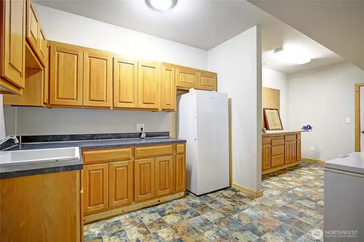 Oversized utility room w/sink, fridge, & tons of storage.