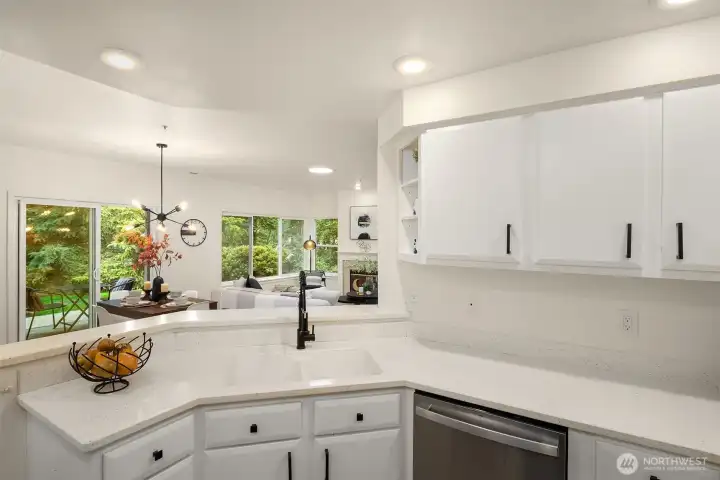 White and bright kitchen cabinets and counter tops, stainless steel appliances, lots of countertop space and storage.