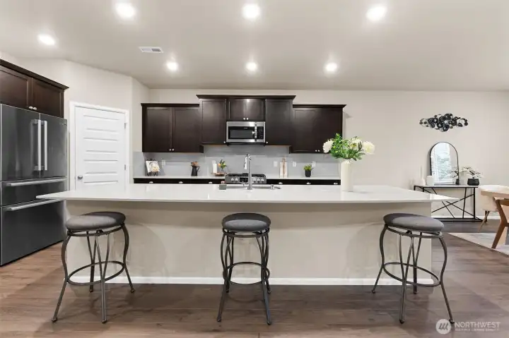 The massive quartz island centers the kitchen.