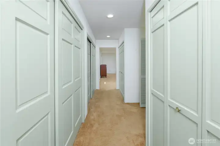 Hallway with lots of closet space and storage begins the primary suite Hallway with lots of closet space and storage begins the primary suite