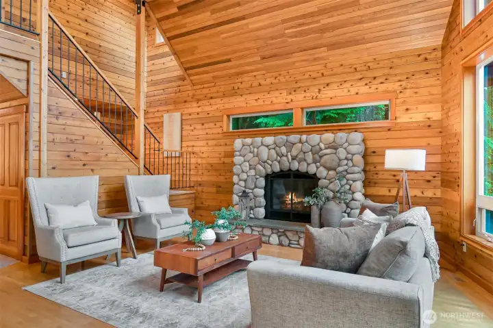A floor-to-ceiling river rock fireplace creates a warm focal point, offering the perfect place to relax after a day of outdoor adventure.