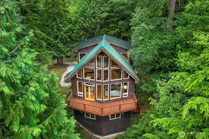 Distinctive Pacific Northwest architecture, expansive windows, and warm cedar accents create a striking first impression while blending beautifully with the surrounding landscape.