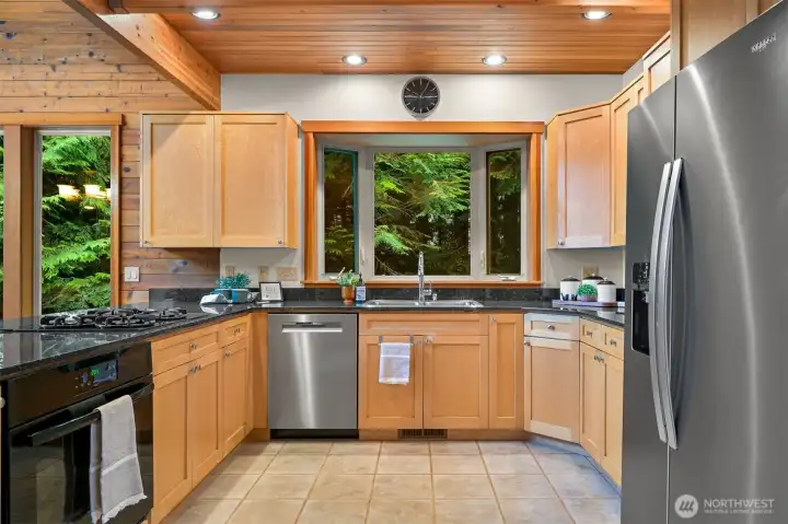 Prepare meals while enjoying peaceful woodland views from the kitchen, complete with generous cabinetry, expansive countertops, and stainless steel appliances.