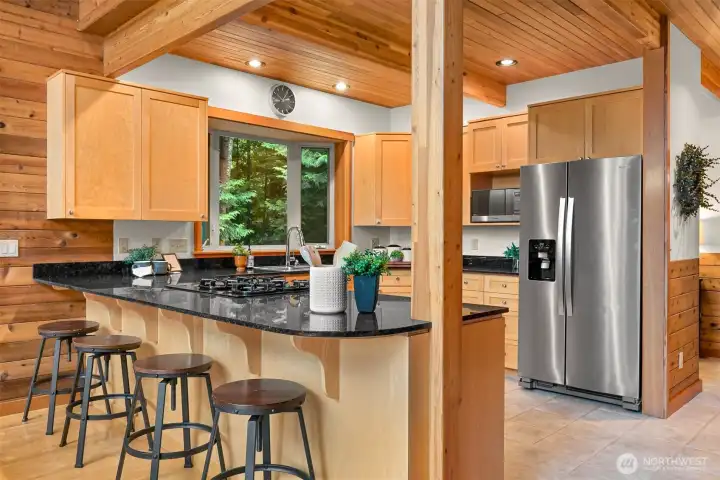 The spacious island offers bar seating, generous prep space, and an ideal gathering place for casual meals, entertaining, or everyday living.