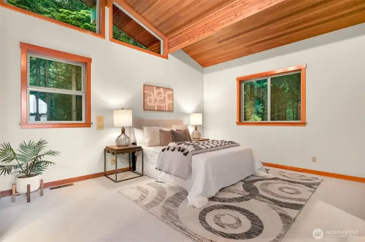 Wake each morning to peaceful forest views in this spacious primary suite, where soaring ceilings and abundant natural light create a relaxing retreat.