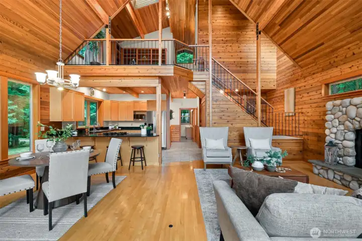 Thoughtfully designed for gathering, the spacious great room showcases dramatic vaulted ceilings, natural wood finishes, and an open loft that enhances the home's sense of space.