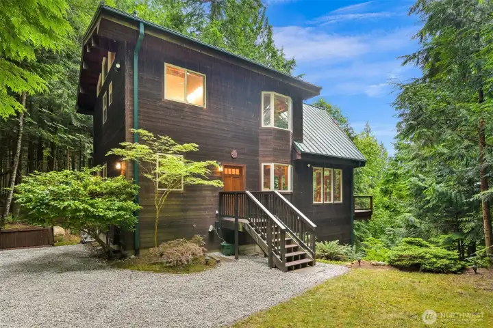 Thoughtfully positioned for privacy, the home blends seamlessly into its natural surroundings while offering low-maintenance landscaping and inviting curb appeal.