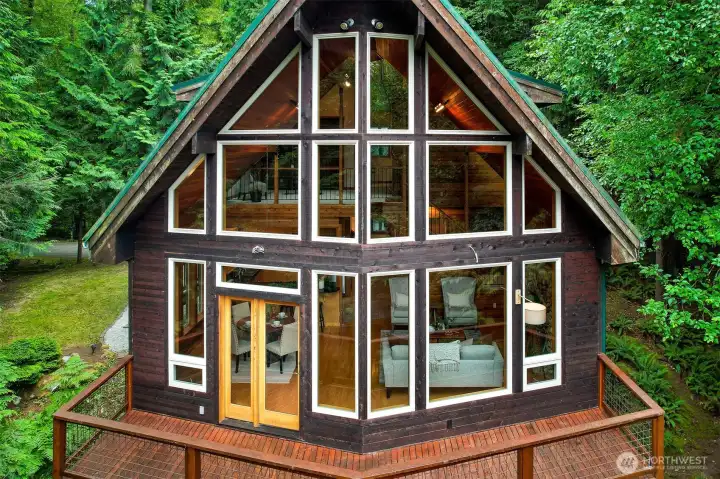 A dramatic wall of windows fills the home with natural light while framing beautiful views of the surrounding forest from nearly every angle.