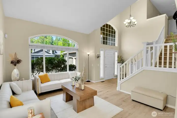 View from the living room showcasing the dramatic two-story foyer and elegant staircase. View from the living room showcasing the dramatic two-story foyer and elegant staircase.