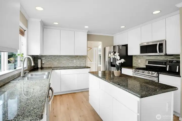 Thoughtfully updated kitchen featuring granite countertops, a center island, stainless steel appliances, and abundant cabinetry. Thoughtfully updated kitchen featuring granite countertops, a center island, stainless steel appliances, and abundant cabinetry.