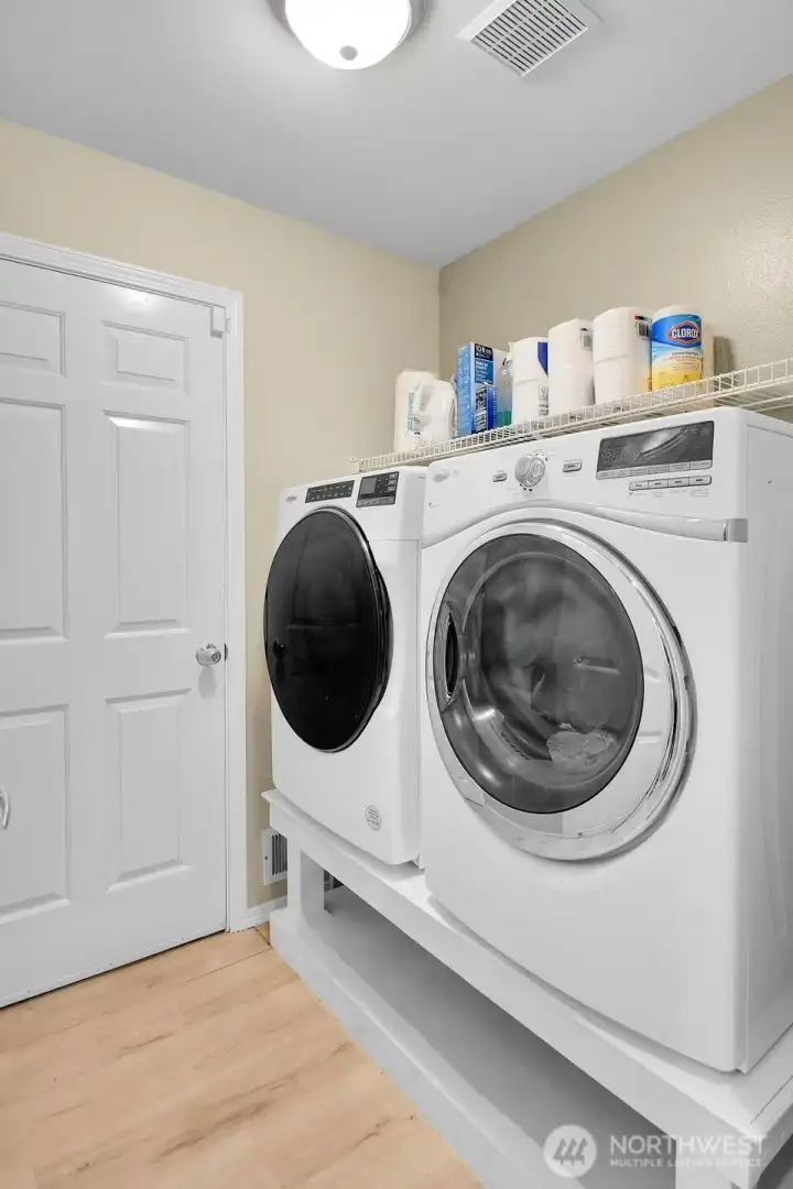 Convenient main floor laundry room with built-in shelving for added storage and organization. Convenient main floor laundry room with built-in shelving for added storage and organization.