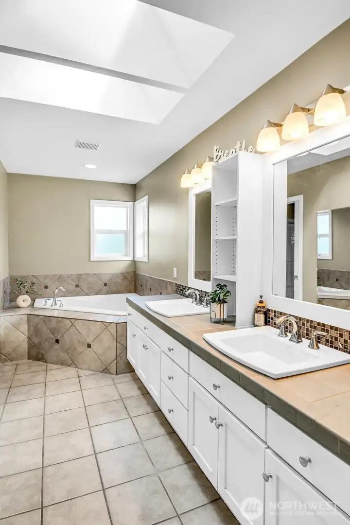 Spa inspired primary bath with dual vanities, skylights, soaking tub, and generous storage. Spa inspired primary bath with dual vanities, skylights, soaking tub, and generous storage.