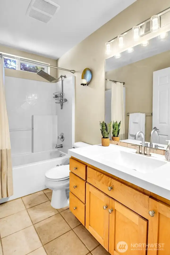 Updated full bath with modern vanity, stylish fixtures, and oversized rainfall showerhead. Updated full bath with modern vanity, stylish fixtures, and oversized rainfall showerhead.