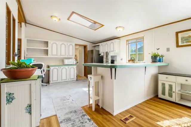 Open kitchen next to the dining room has lots of natural light, including a skylight. The flooring is in great shape!