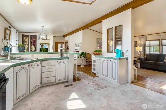 Open concept kitchen peeks into the front living room. A coffee bar sits over on the right.