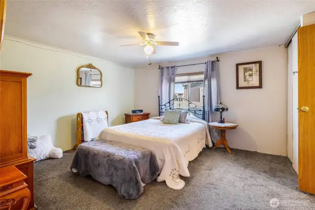 Primary bedroom with a full bathroom to the right.  Enjoy the ceiling fan to cool the air.