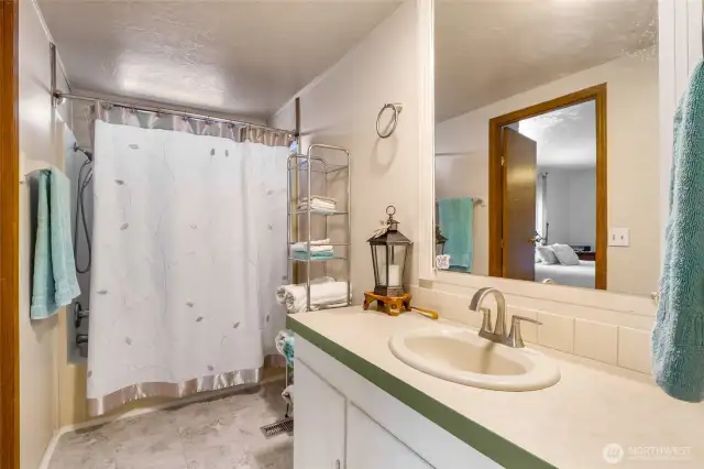 Primary bathroom has a tub/shower combo and plenty of counter space.