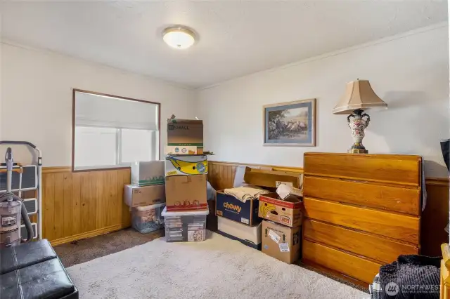 Down by the family room is this second bedroom with chair-rail accents and full carpeting under the large area rug.