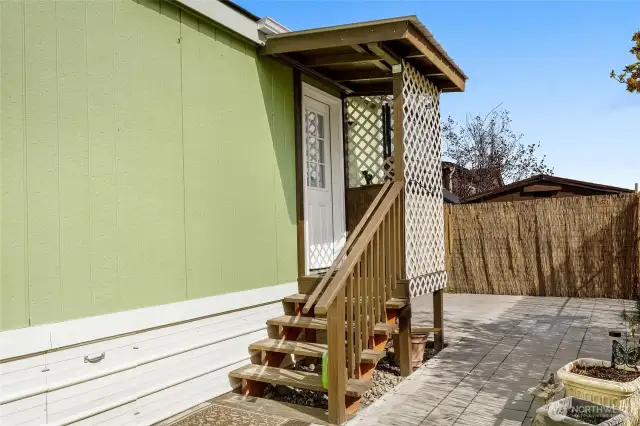 Covered back porch, privacy bamboo panels on six foot fence, nice shade tree nearby, crawl space access. Back porch door is entry into the laundry room.
