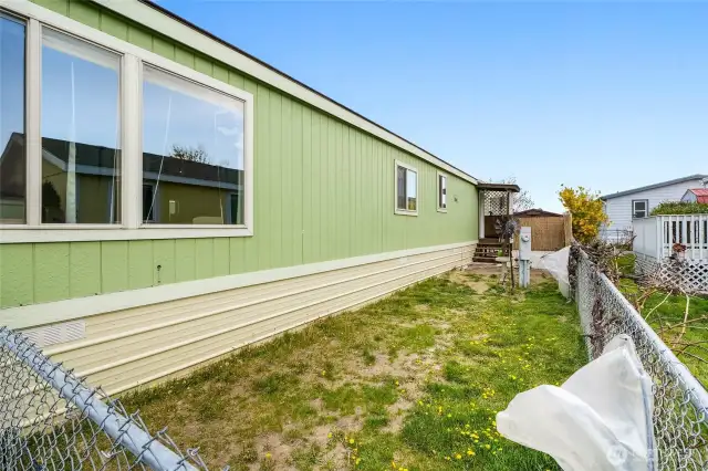 Just a wee bit of grass on the side yard on the left for your pets. Plastic-coverd frame shades tender plants.