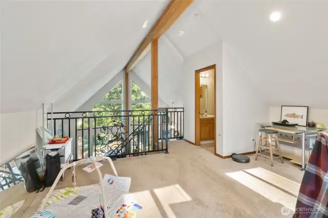 The beam work continues through to the loft.  Peaked ceilings and the look through space out to the front of the house make this loft feel spacious and open.
