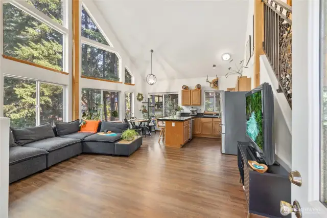 Upon entering the home, you take in the open concept of this build.  Living space, kitchen and dining space all together paired with vaulted ceilings and massive windows to achieve an open air and spacious feeling throughout.