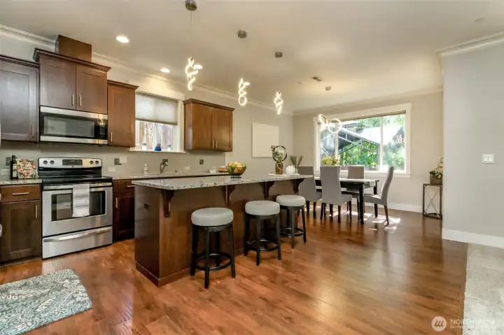 Spacious Kitchen with granite counters, solid wood cabinets, pantry, stainless steel appliances & breakfast bar.