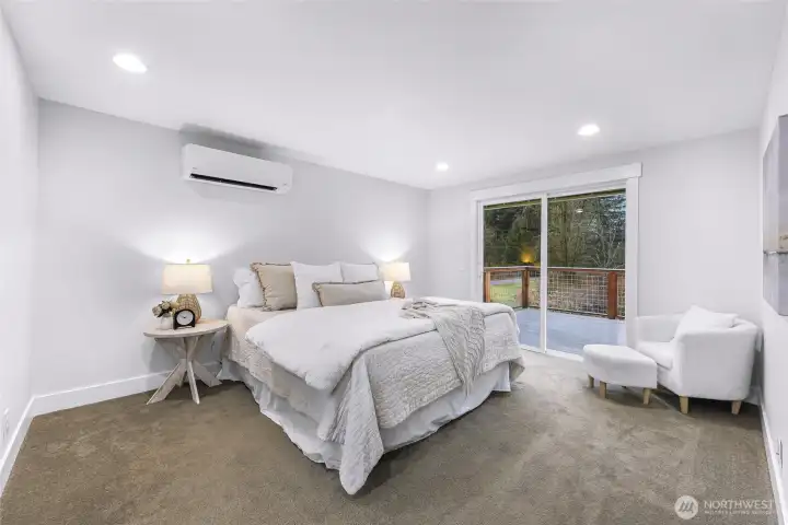 Bright primary bedroom with private deck access through slider