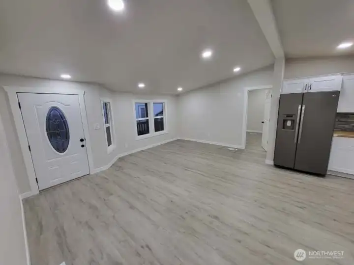 Heading toward the doorway next to the fridge, into room #1 (that has full bath directly off)