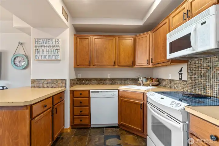 View 4 of lower level living/media room w/ fireplace, dining area and 2nd kitchen w/ doors leading out to the patio w/ pool, hot tub, basketball court and dining and lounge area.