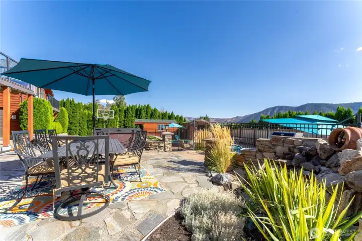 Daylight view of the outdoor living space w/ dining, lounge and BBQ areas, pool and hot tub.