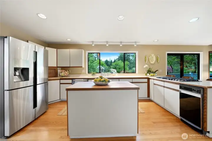 Butcher block island, 4-door french door refrigerator, JennAir gas downdraft cooktop, double ovens and yes, that's a working trash compactor!
