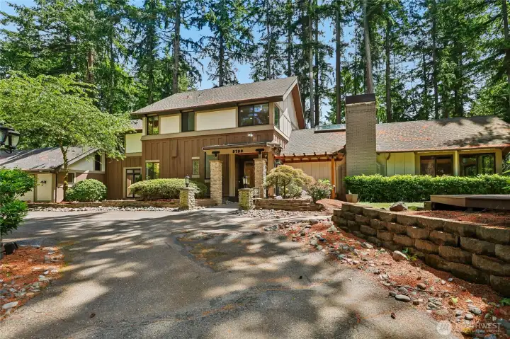 Whimsical circular driveway greets you with room for RV parking, if you please.