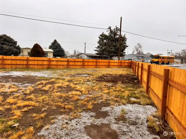 Fully fenced front yard with two gated access points.