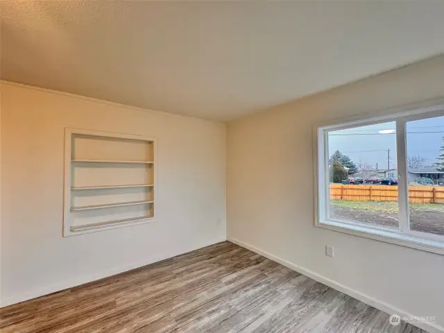 View to the right side of the living room. Built in book case and corner windows for lots of light.