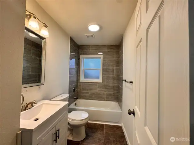 Brand new bathroom with tile shower and floor.