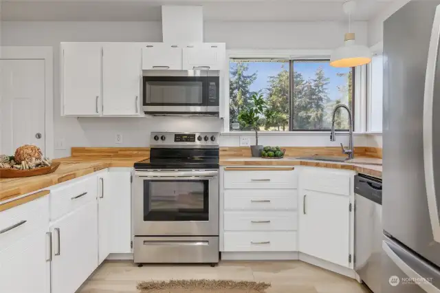 Butcher block countertop, updated hardware and lighting, and stainless appliances.