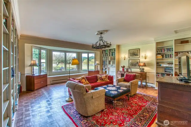 The library is a welcome room to relax. A bay window brings more light to the space.