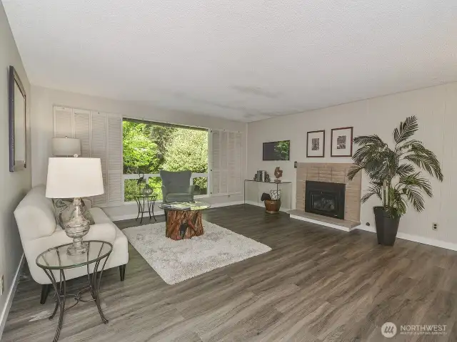 Nice living room with new floors and new cozy gas fireplace.