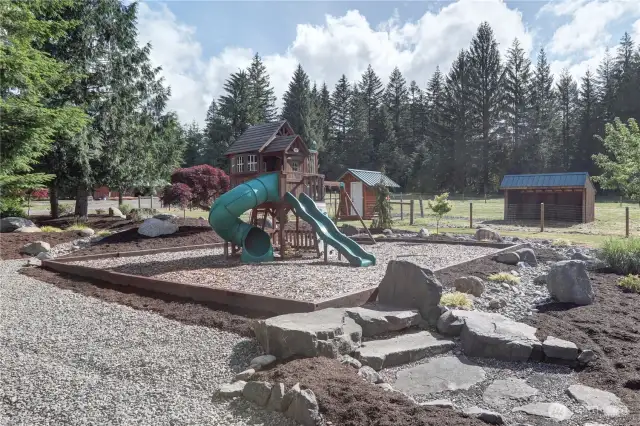 Lush landscaping throughout. Kids play area