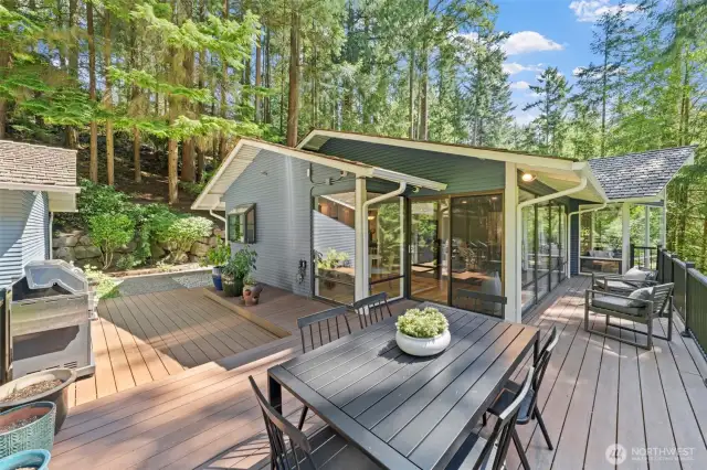 Wall-to-wall windows blur the line between indoors and out, while the expansive deck serves as the perfect extension of the home’s living space—ideal for entertaining or unwinding.