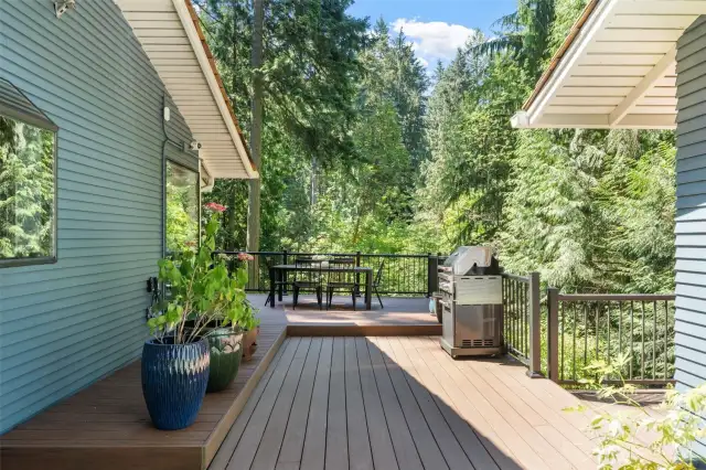 Step up from the right side of the driveway and onto the spacious deck that seamlessly connects the detached garage, main house, and lower level.