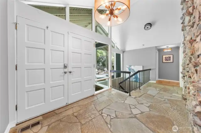 Step inside to soaring ceilings, natural stone floors, and an abundance of glass that effortlessly blends indoor living with the lush surroundings outside.