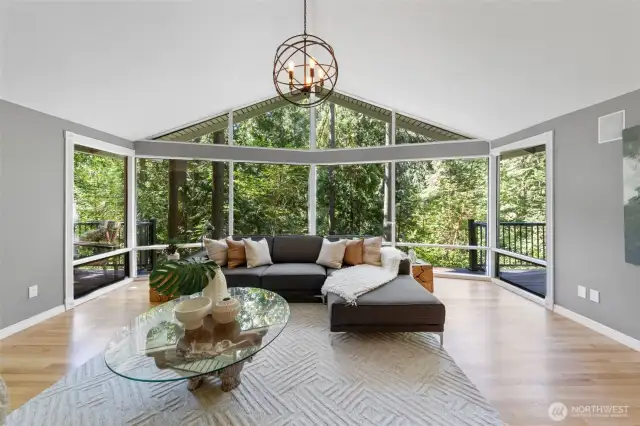 Bathed in natural light and surrounded by serene forest views, the main living room is the heart of the home. Vaulted ceilings and a wall of windows create a sense of openness and calm.