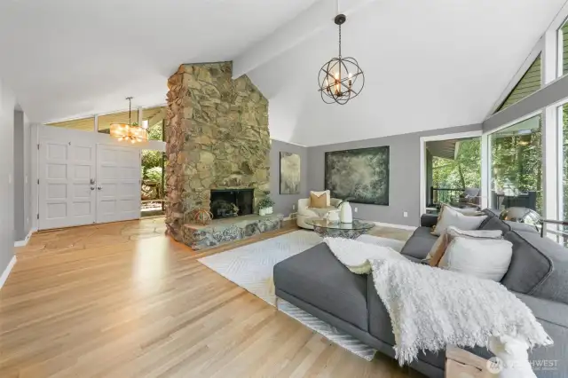 A dramatic stone fireplace anchors the spacious living room, balancing mid-century character with modern comfort. Just off the entryway, this warm and welcoming space is perfect for quiet evenings or hosting guests in style.