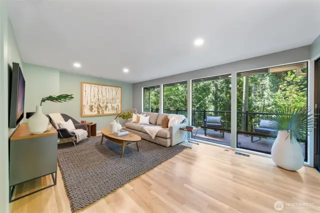 Tucked off the kitchen, this inviting family space is framed by floor-to-ceiling windows that showcase lush, tree-filled views, and peaceful place to relax, read, or unwind.