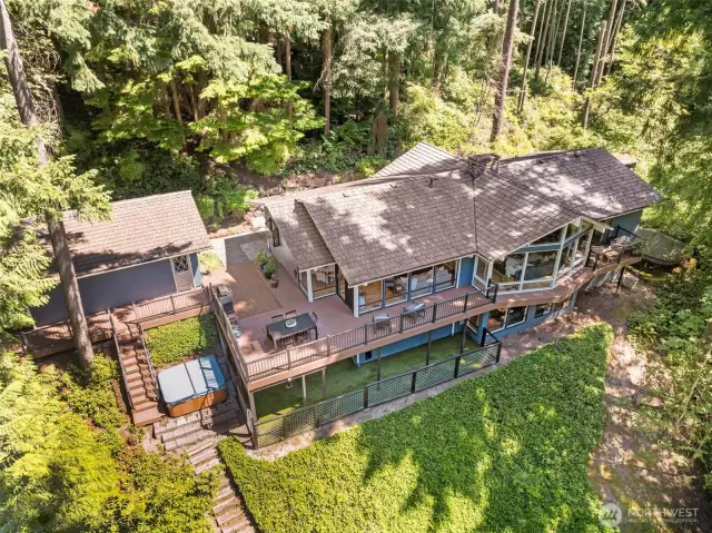A stunning perspective showcasing this expansive 1-story with basement home—complete with an entertainer’s dream deck, a serene hot tub retreat, and ultimate privacy surrounded by lush Bridle Trails forest.