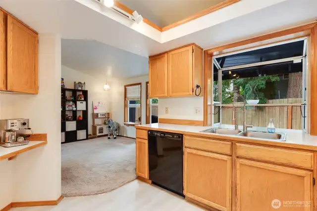 Bright kitchen layout with breakfast bar, updated LVP tile flooring, and seamless access to the living rm & flex bonus room.