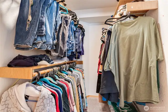 Walk-in closet with built-in shelving and rods keeps everything neat and organized.