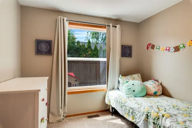 Third bedroom with large window and room to grow, play, or rest.